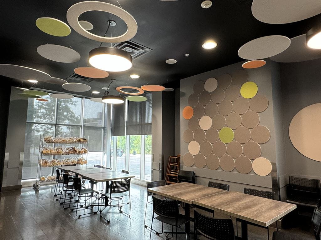 The updated common space at Kerr Street Mission, including colourful acoustic tiles suspended from the ceiling and attached to the wall